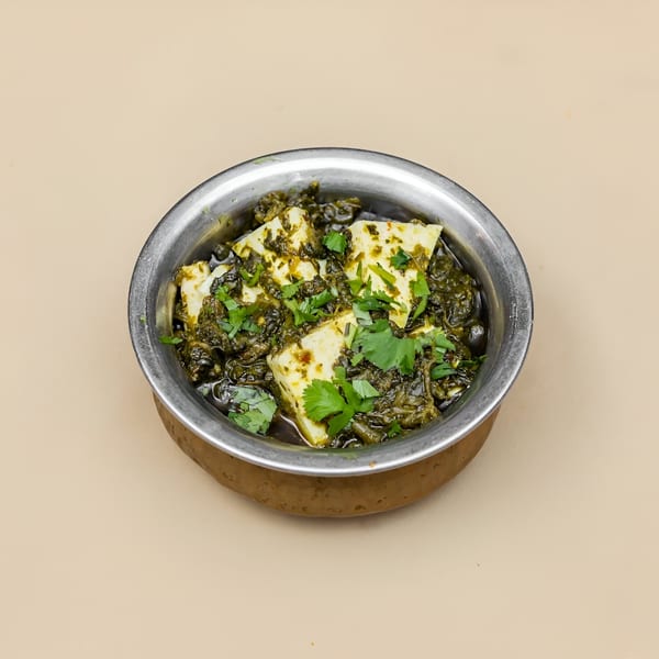 Palak Paneer, a Pakistani dish with spinach and cheese, in a metal bowl.